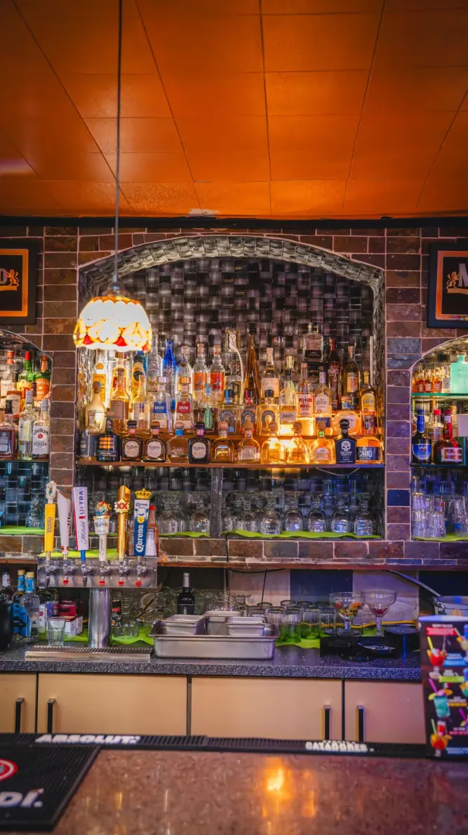 The tequila wall under the brick arch at the bar