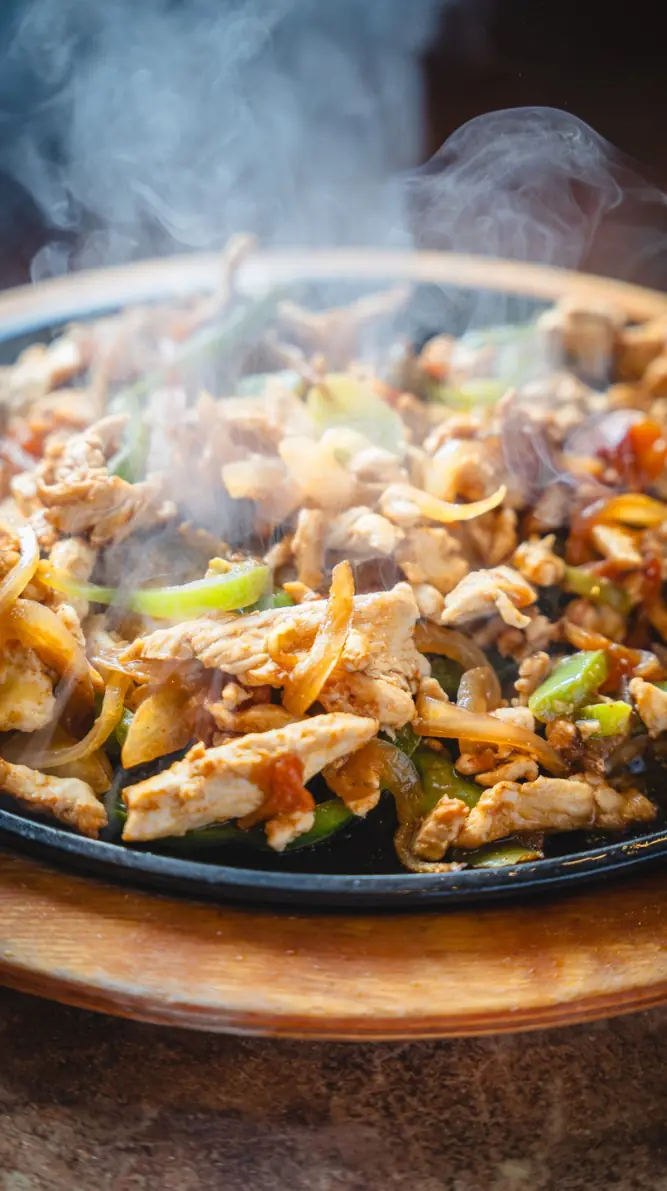 Chicken fajitas smoking on a skillet