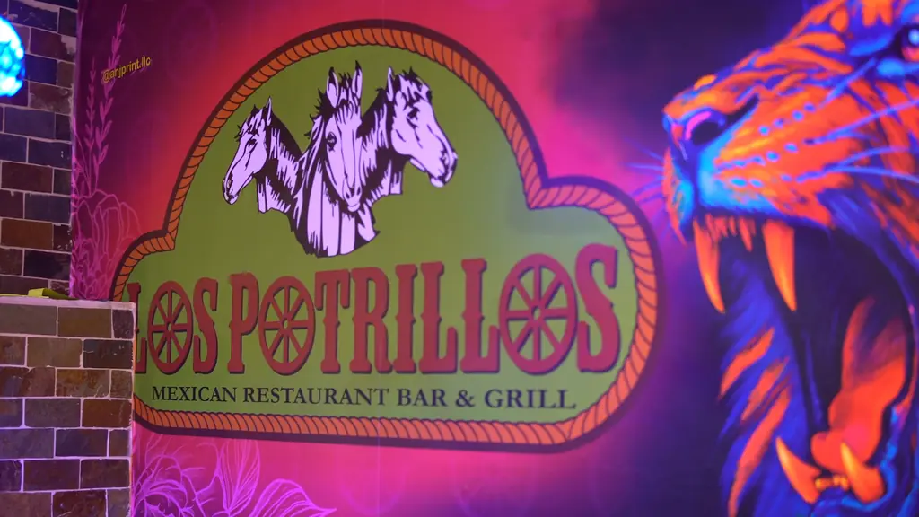 The Los Potrillos wall mural: the three-horse logo beside a neon tiger