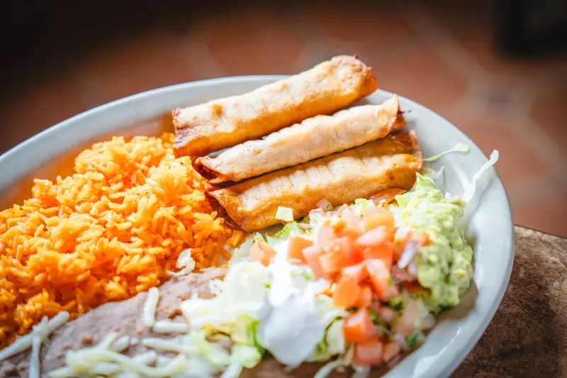 Taquitos Potrillos with rice, beans, guacamole and pico